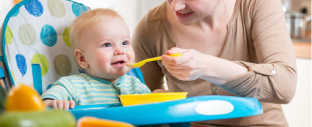 mother spoon-feeding baby