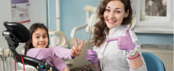 dentist and child smiling in dental chair