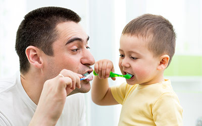 Dad Teaching His Son to Brush His Teeth